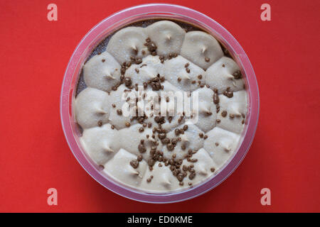 Il cioccolato al latte e caramello cheesecake isolato su sfondo rosso Foto Stock