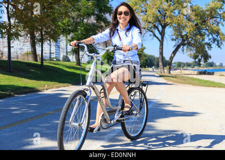 Giovane donna asiatica in sella la sua bici sul Lago Michigan nel lato sud di Chicago, IL, Stati Uniti d'America. Foto Stock