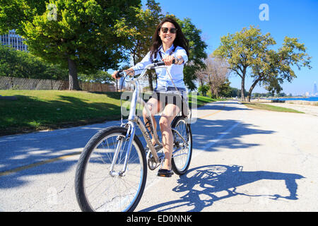 Giovane donna asiatica in sella la sua bici sul Lago Michigan nel lato sud di Chicago, IL, Stati Uniti d'America. Foto Stock