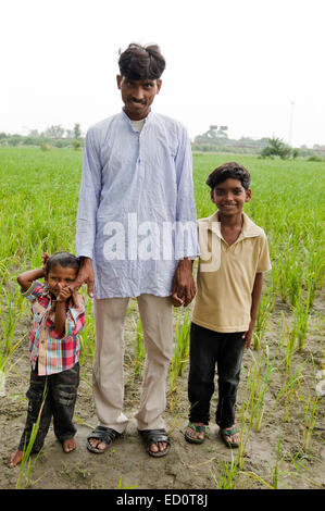 Rurale indiano padre con campo secondario Foto Stock