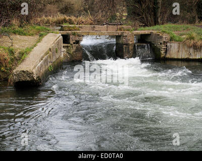 L'acqua precipita attraverso l'apertura a saracinesca del vecchio blocco flash atComptonLock sulla navigazione Itchen vicino a Winchester. Foto Stock