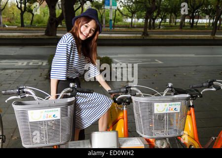 TAIPEI CITY, TAIPEI, Taiwan. Novembre 19, 2014. Donna in posa da U-bike noleggi biciclette; U-bike è un'iniziativa di Taipei City Foto Stock