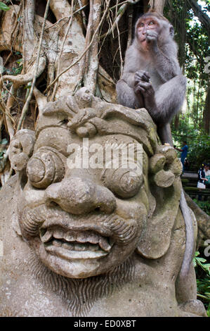 Le scimmie avendo divertimento sulle statue in pietra di sante indù Monkey Forest. Ubud. Bali. Risate. L'Ubud Monkey Forest è una riserva naturale Foto Stock