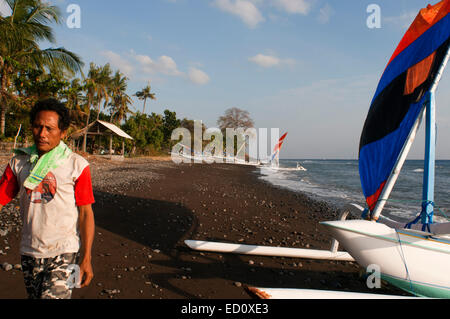 Alcuni pescatori prendere le loro barche a terra vicino alla Spiaggia di Amed, un villaggio di pescatori nella parte Est di Bali. Amed è un litorale lungo st Foto Stock