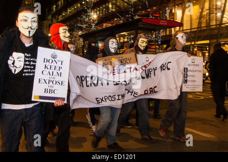 Londra, Regno Unito. 23 dic 2014. Attivismo Online gruppo anonimo marzo a Londra dalla città per la BBC ha il suo quartier generale a Great Portland Street in segno di protesta contro le presunte polarizza e coverups di un "anello di pedofilia". Nella foto: manifestanti marzo verso il West End dalla Banca d'Inghilterra. Credito: Paolo Davey/Alamy Live News Foto Stock