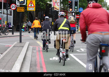 I ciclisti che viaggiano lungo una strada a Waterloo, Londra, accanto a "pensare moto' firmare Foto Stock
