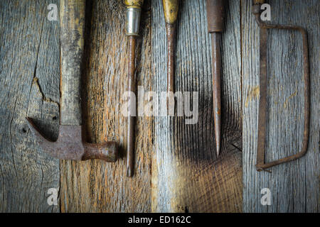 Sega a mano, martello e cacciaviti su legno rustico sfondo Foto Stock