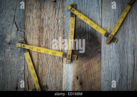Il nastro vecchio misurare su legno rustico sfondo Foto Stock