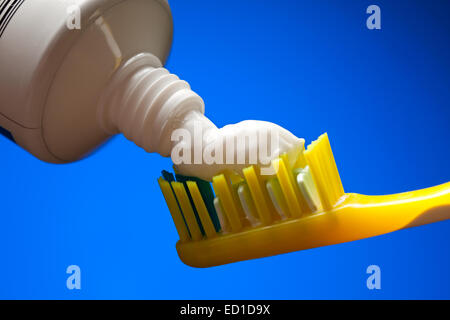 Spazzolino da denti e dentifricio su uno sfondo blu Foto Stock