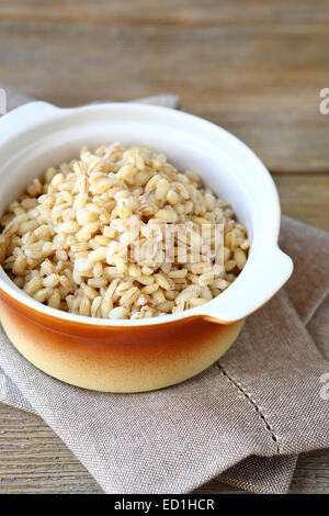 Bollito di farro in un vaso di ceramica, cibo su un tavole di legno Foto Stock