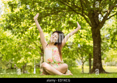 Rilassata giovane donna seduta in posizione di parcheggio Foto Stock