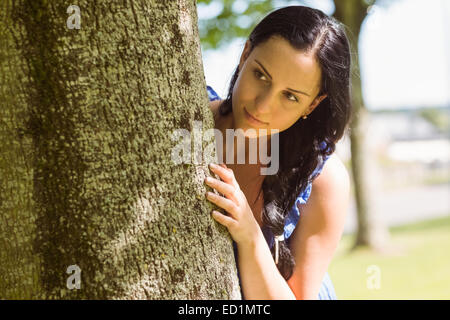 Bella bruna appoggiato a un albero Foto Stock