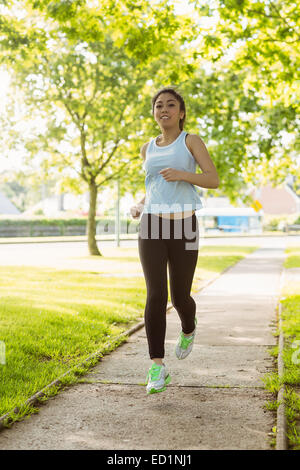 Montare la giovane donna jogging nel parco Foto Stock