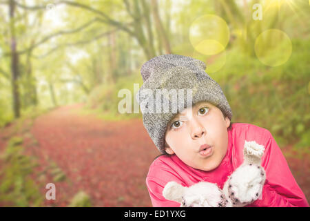 Immagine composita di avvolto bambina soffiare via le mani Foto Stock