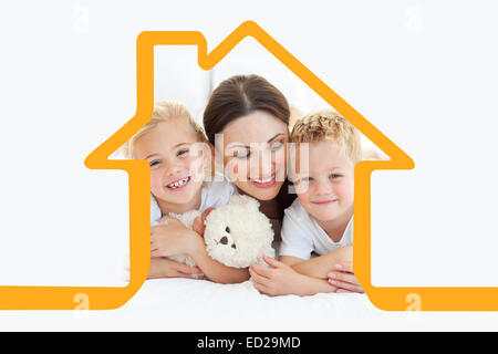 Immagine composita di allegro bambini con la loro madre giacente su un letto Foto Stock