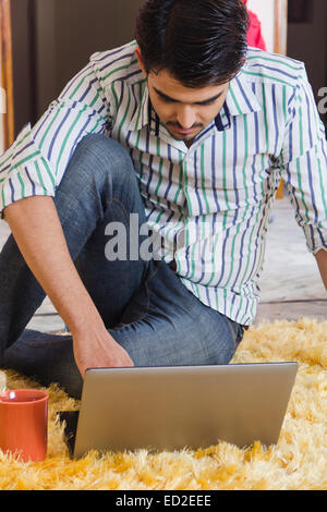 1 uomo indiano notebook di casa a lavorare Foto Stock