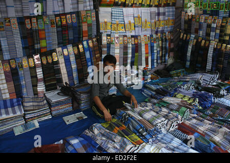 Un vestito del Bangladesh fornitore egli attende i clienti in un mercato all'ingrosso a karwan Bazar a Dhaka il 24 dicembre 2014. L'agricoltura, la spina dorsale del Bangladesh con circa il 60-70% delle persone a seconda l'agricoltura è la fonte principale dell'economia del paese e comprende circa il 15% del PIL del paese e il 60% del totale della forza lavoro. Foto Stock