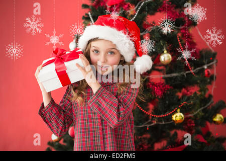 Immagine composita di festosa bambina dono di contenimento Foto Stock