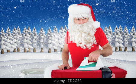 Immagine composita di felice santa claus stirare la sua camicia Foto Stock