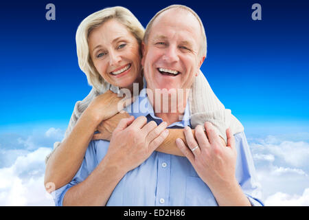 Immagine composita di felice coppia matura abbracciando sorridente in telecamera Foto Stock