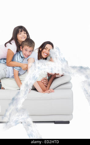 Immagine composita dei bambini che giacciono sul loro genitori sul divano Foto Stock