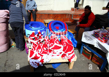 La Paz, Bolivia, 24 dicembre 2014. Una bancarella vendendo Santa Claus cane cappotti in un mercato di Natale. Credito: James Brunker / Alamy Live News Foto Stock