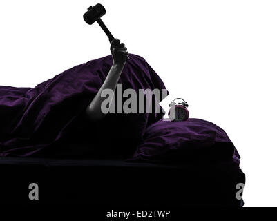 Una persona smashing sveglia nel letto di svegliarvi smashing sveglia silhouette studio su sfondo bianco Foto Stock