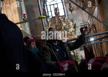 Betlemme, West Bank. 24 dicembre, 2014. Turisti asiatici all'interno della chiesa della Natività di Betlemme durante le celebrazioni del Natale. Credito: Mustafa Bader/ZUMA filo/Alamy Live News Foto Stock