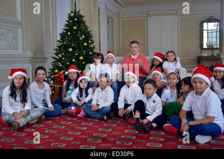 Bogotà, Colombia. 24 dicembre, 2014. Immagine fornita da Colombia assumerà la Presidenza mostra il presidente colombiano Juan Manuel Santos (C-back) offrendo una vigilia di Natale discorso al Palazzo Presidenziale, a Bogotà, Colombia, il 24 dicembre, 2014. Credito: Juan Pablo Bello/Colombia la Presidenza/Xinhua/Alamy Live News Foto Stock