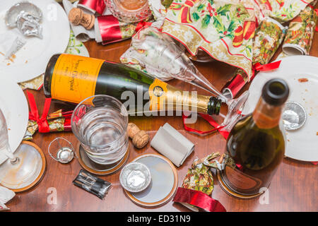 I detriti in postumi di una stagione festiva parte con un vuoto di Veuve Clicquot bottiglia di champagne e di altri rifiuti Foto Stock