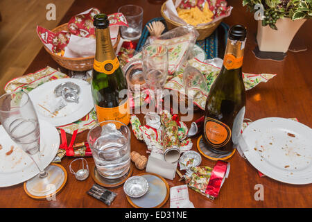 I detriti in postumi di una stagione festiva parte con un vuoto di Veuve Clicquot bottiglia di champagne e di altri rifiuti Foto Stock