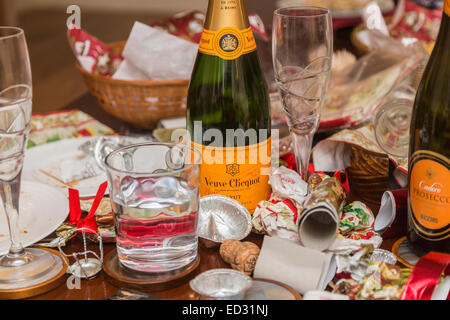 I detriti in postumi di una stagione festiva parte con un vuoto di Veuve Clicquot bottiglia di champagne e di altri rifiuti Foto Stock