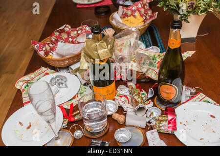 I detriti in postumi di una stagione festiva parte con un vuoto di Veuve Clicquot bottiglia di champagne e di altri rifiuti Foto Stock
