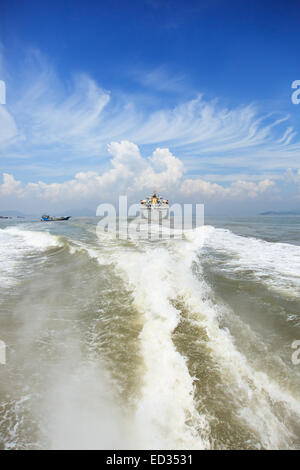 Barca wake e cargo al mare Foto Stock