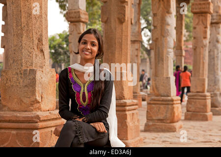 Giovane donna indiana a lui il chiostro delle colonne della Quwwat ul-Islam moschea, Qutb complessa, Sito Patrimonio Mondiale dell'UNESCO a Delhi, indi Foto Stock