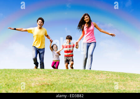 Indian genitori con parco per bambini in esecuzione Foto Stock