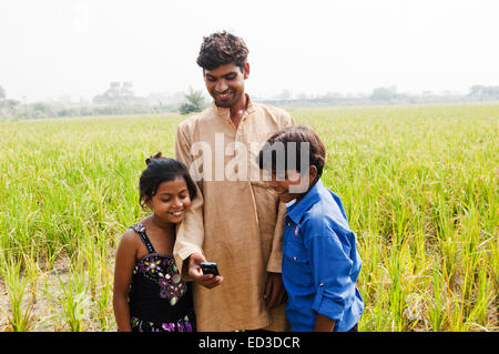 Indian rurale e contadino bambino Farm telefono di composizione Foto Stock