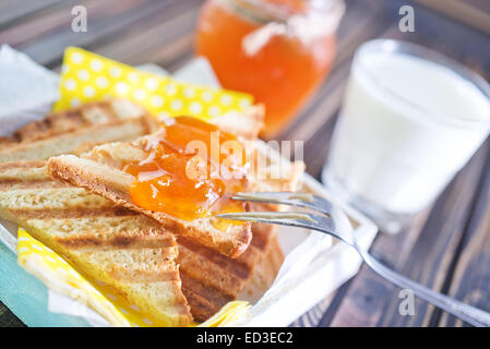Toast con marmellata in banca e su un tavolo Foto Stock