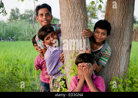 Indian bambini rurali gruppo farm di giocare a nascondino Foto Stock