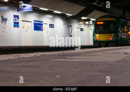 Il livello del suolo vista la piattaforma presso la stazione ferroviaria Birmingham New Street a Londra Midland treno regionale in background Foto Stock