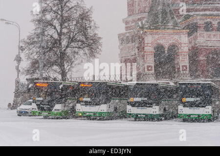 Mosca, Russia. 25 dicembre, 2014. Meteo: Heavy snowstorm oggi a Mosca. Freddo e ventoso giorno, bassa temperatura fino a -8C (-22F) e neve pesante. La prima tempesta di neve nella stagione dopo un mese di caligine e sporcizia. Stagione invernale infine arrivò al potere alla vigilia del nuovo anno e del Natale ortodosso vacanze. Gli autobus attendere per i bambini che frequentano il matinée al Cremlino, dalla cattedrale di San Basilio. Credito: Alex Immagini/Alamy Live News Foto Stock