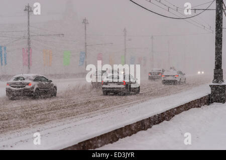 Mosca, Russia. 25 dicembre, 2014. Meteo: Heavy snowstorm oggi a Mosca. Freddo e ventoso giorno, bassa temperatura fino a -8C (-22F) e neve pesante. La prima tempesta di neve nella stagione dopo un mese di caligine e sporcizia. Stagione invernale infine arrivò al potere alla vigilia del nuovo anno e del Natale ortodosso vacanze. Automobili per le strade di Mosca nella tempesta di neve. Credito: Alex Immagini/Alamy Live News Foto Stock