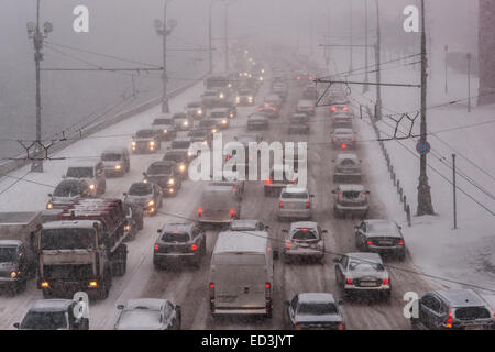 Mosca, Russia. 25 dicembre, 2014. Meteo: Heavy snowstorm oggi a Mosca. Freddo e ventoso giorno, bassa temperatura fino a -8C (-22F) e neve pesante. La prima tempesta di neve nella stagione dopo un mese di caligine e sporcizia. Stagione invernale infine arrivò al potere alla vigilia del nuovo anno e del Natale ortodosso vacanze. Traffico sul Cremlino argine del fiume di Mosca. Credito: Alex Immagini/Alamy Live News Foto Stock