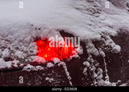 Mosca, Russia. 25 dicembre, 2014. Meteo: Heavy snowstorm oggi a Mosca. Freddo e ventoso giorno, bassa temperatura fino a -8C (-22F) e neve pesante. La prima tempesta di neve nella stagione dopo un mese di caligine e sporcizia. Stagione invernale infine arrivò al potere alla vigilia del nuovo anno e del Natale ortodosso vacanze. Luce di coda della vettura in pesante tempesta di neve. Credito: Alex Immagini/Alamy Live News Foto Stock