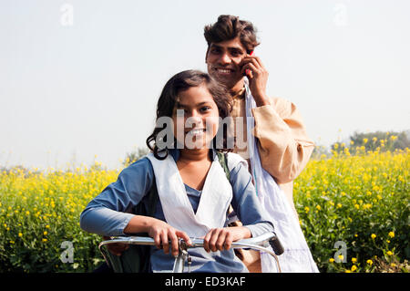 L'agricoltore indiano e la figlia del ciclo di equitazione Foto Stock