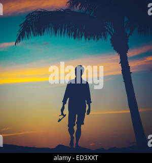 L'uomo passeggiando su una spiaggia alle Hawaii Foto Stock