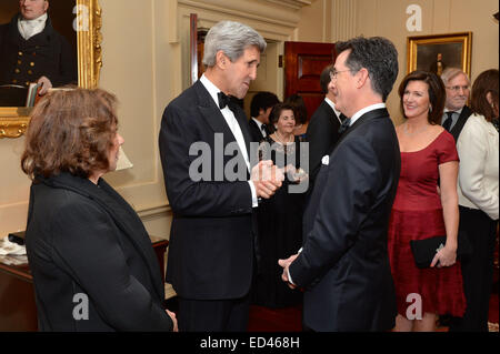 Con Teresa Heinz Kerry guardando, U.S. Il segretario di Stato John Kerry saluta Comedy Central show host Stephen Colbert, che emceed il 2014 Kennedy Center Honors, prima di una cena che il segretario ha ospitato in onore del 2014 il Centro Kennedy evento, presso l'U.S. Il Dipartimento di Stato a Washington D.C., il 6 dicembre 2014. Foto Stock