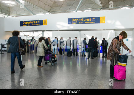 Passeggeri e viaggiatori che attraversano la zona Partenze presso l'aeroporto di Londra Stansted Essex Inghilterra Regno Unito Regno Unito Foto Stock