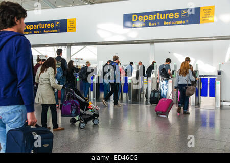 Passeggeri e viaggiatori che attraversano la zona Partenze presso l'aeroporto di Londra Stansted Essex Inghilterra Regno Unito Regno Unito Foto Stock