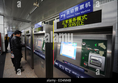 (141227) -- PECHINO, Dic 27, 2014 (Xinhua) -- passeggeri acquistano i biglietti della metropolitana sul ticket di distributori automatici a Sihuidong Stazione della metropolitana di Pechino, capitale della Cina, Dic 27, 2014. Pechino inizierà a sollevare le sue tariffe su mezzi di trasporto pubblico il 28 dicembre, il raddoppio dei prezzi correnti in media, ma compresi alcuni regimi di sconto. Secondo il prezzo piano di adeguamento, il prezzo minimo per un tragitto in metropolitana sarà 3 yuan, che copre un giro di 6 km, a confronto con la corrente flat-tariffa di 2 yuan con trasferimenti illimitati. Per i passeggeri di un autobus, una corsa di 10 km sarà di 2 yuan e 1 yuan per ogni pelo Foto Stock